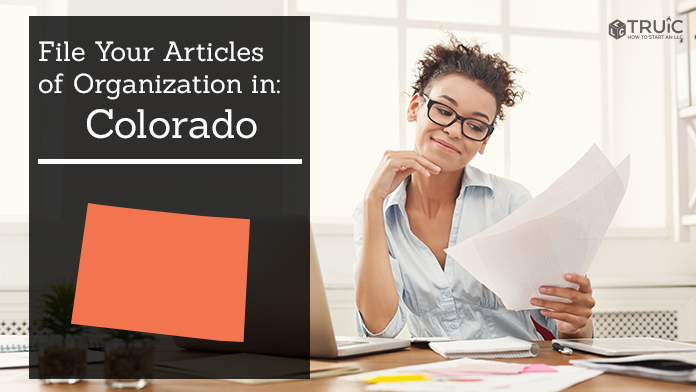 Woman smiling while looking at her articles of organization for Colorado.