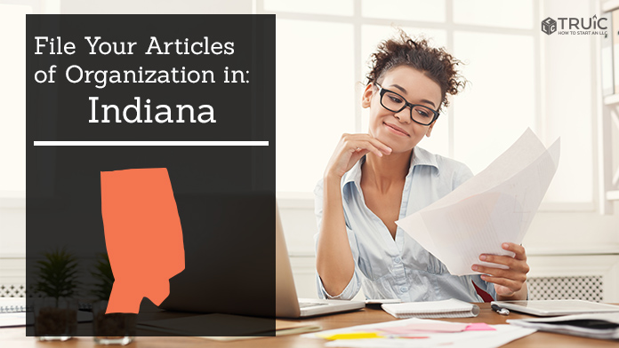 Woman smiling while looking at her articles of organization for Indiana.