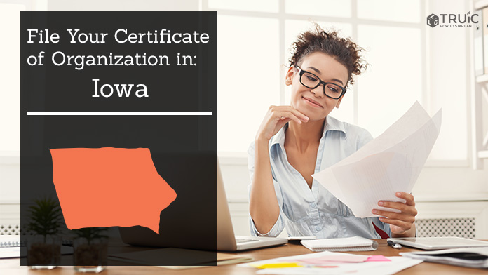 Woman smiling while looking at her certificate of organization for Iowa.