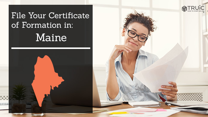 Woman smiling while looking at her certificate of formation for Maine.