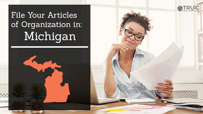 Woman smiling while looking at her articles of organization for Michigan.