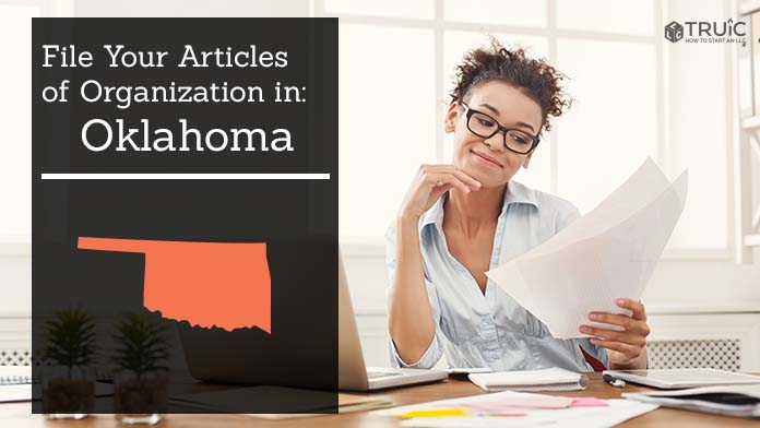 Woman smiling while looking at her articles of organization for Oklahoma.