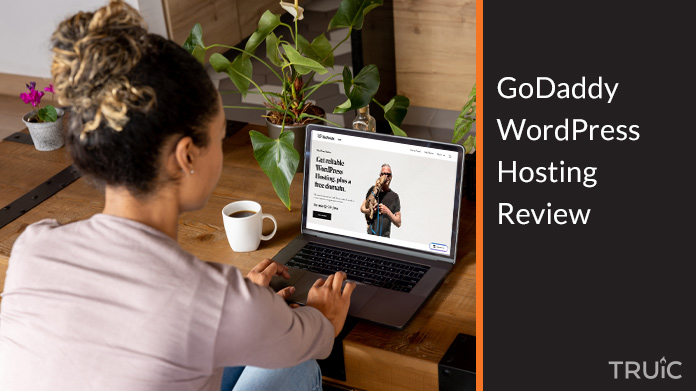 Woman on a computer looking at GoDaddy's WordPress Hosting page.