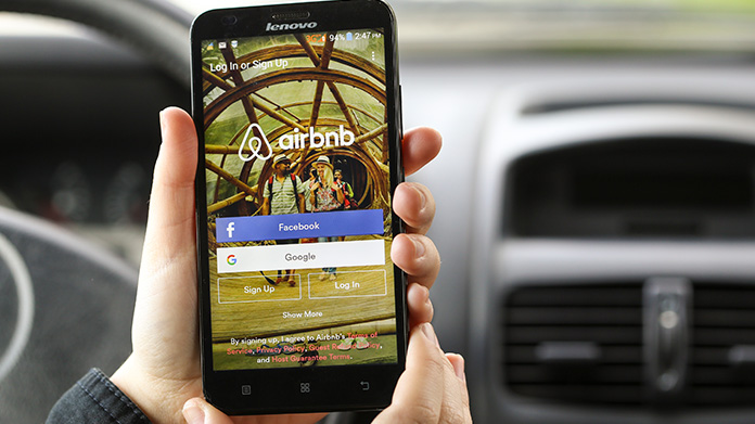 A cellphone with the Airbnb app on the screen