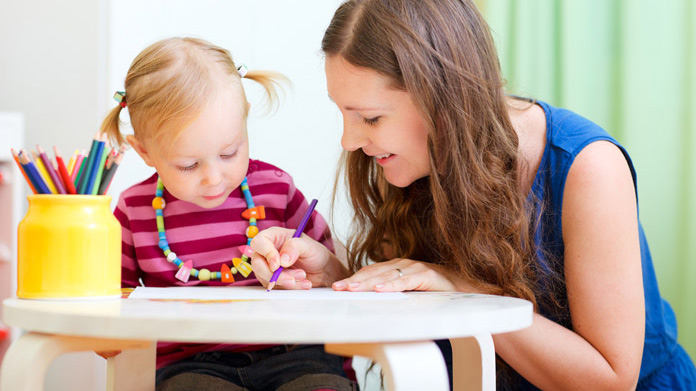 Woman sitting with a child drawing