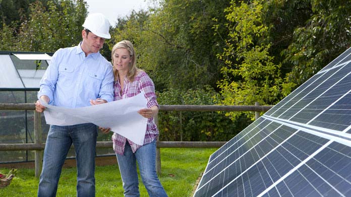 Two people looking over a Solar Panel