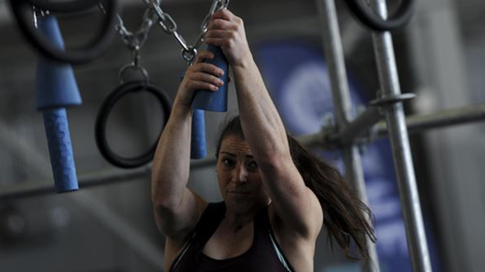 Woman swinging from hanging gym