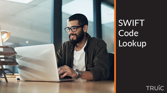 Smiling entrepreneur searching for a SWIFT code